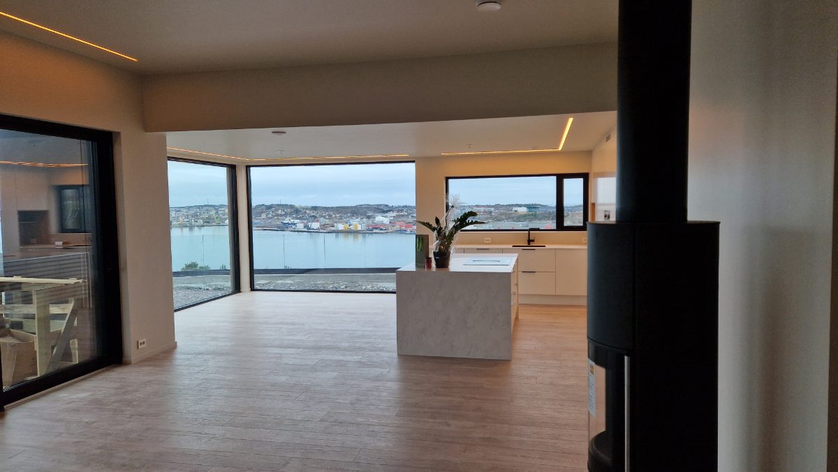 Åpen kjøkken- og stueløsning med panoramautsikt mot sjøen